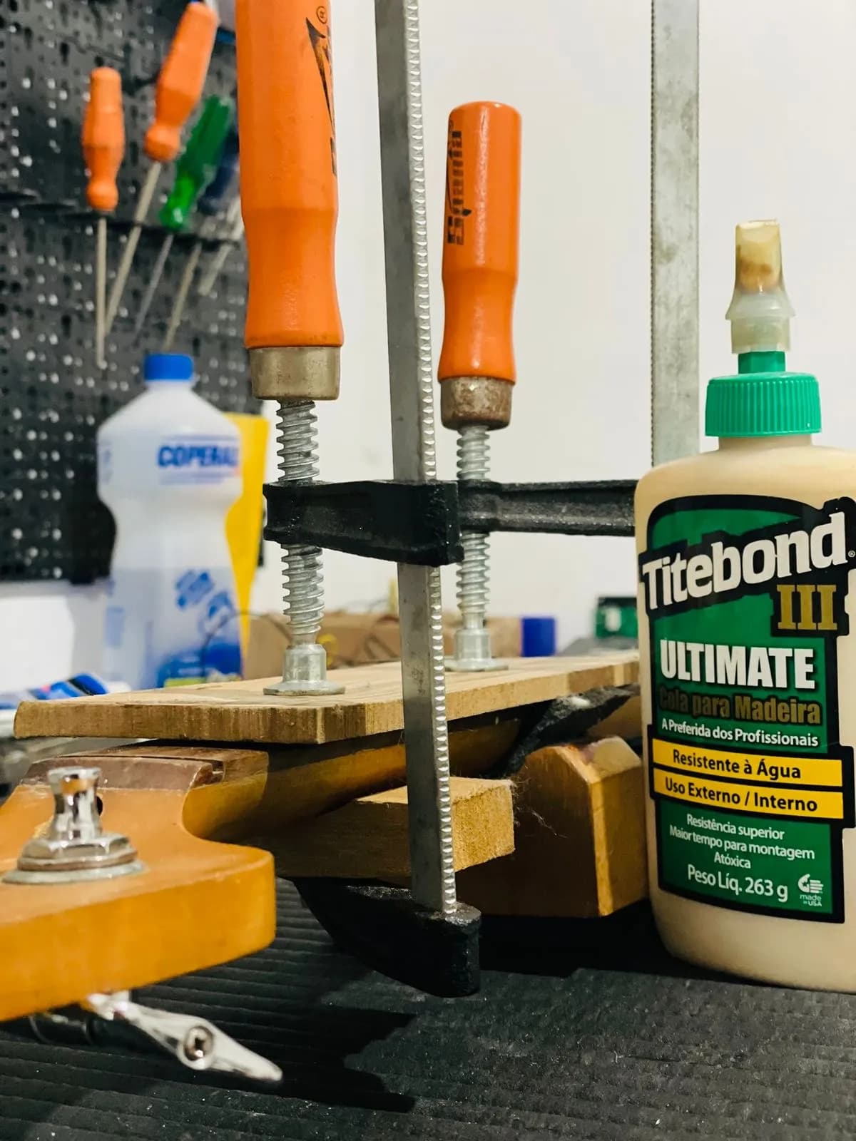 Guitarra vermelha metálica na bancada de regulagem