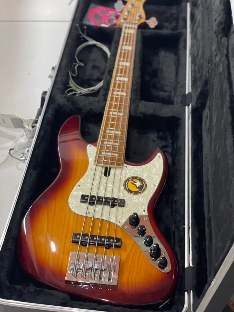 Contrabaixo jazz bass de cinco cordas sunburst com escudo perolado dentro do case