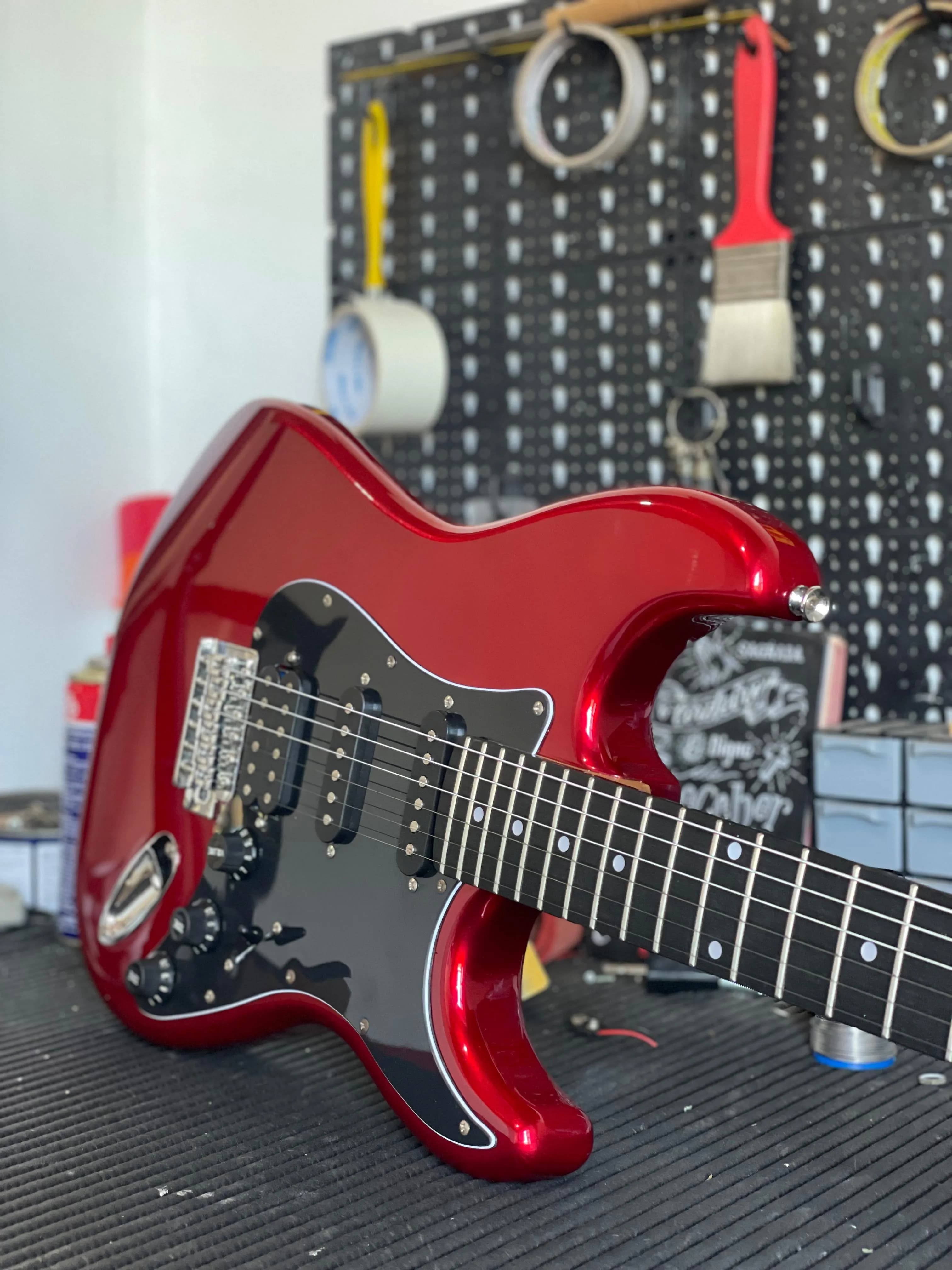 Baixo Yamaha vermelho e dourado na bancada do luthier