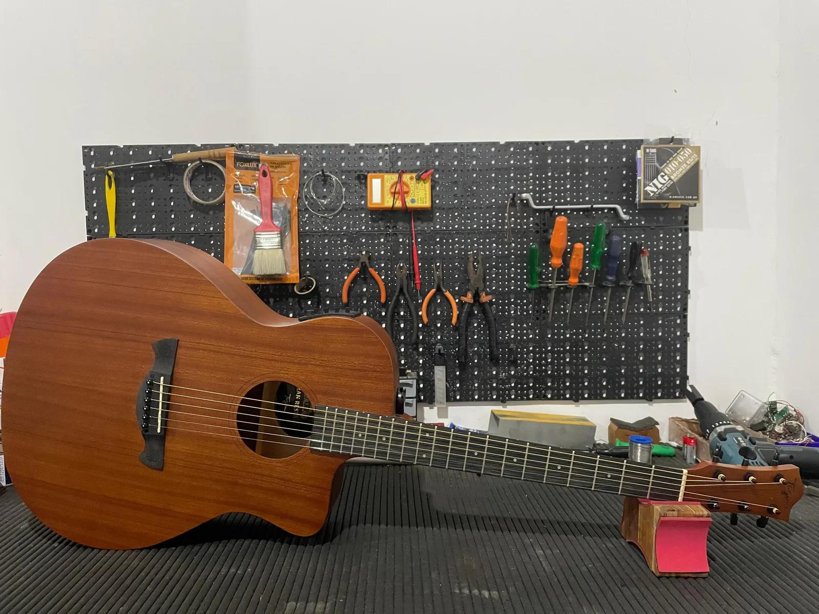 Bancada da oficina Alves Luthieria com violão e painel de ferramentas