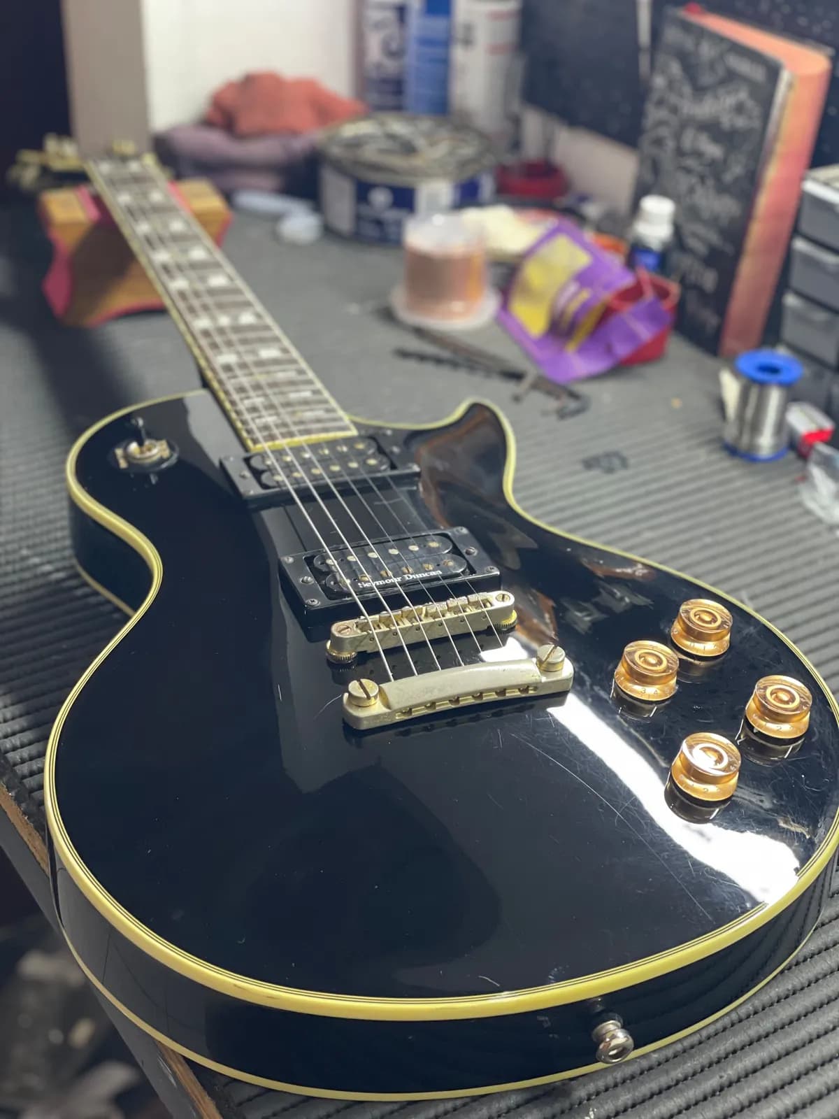 Guitarra estilo Les Paul Custom preta com captador Seymour Duncan na bancada de regulagem