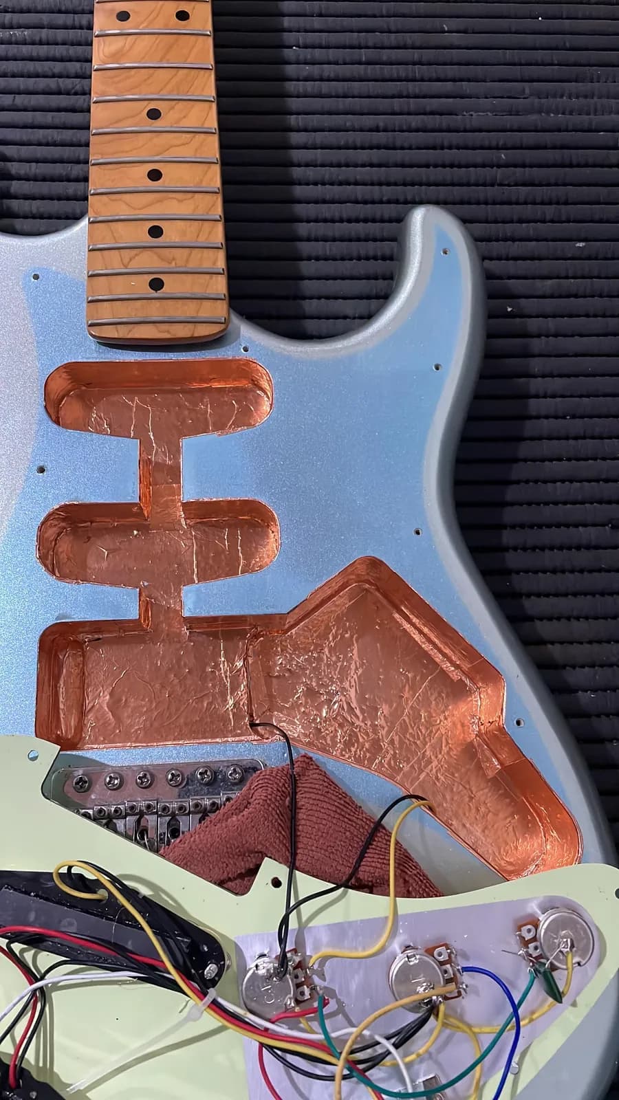 Blindagem elétrica em andamento: cavidades de guitarra revestidas com fita de cobre