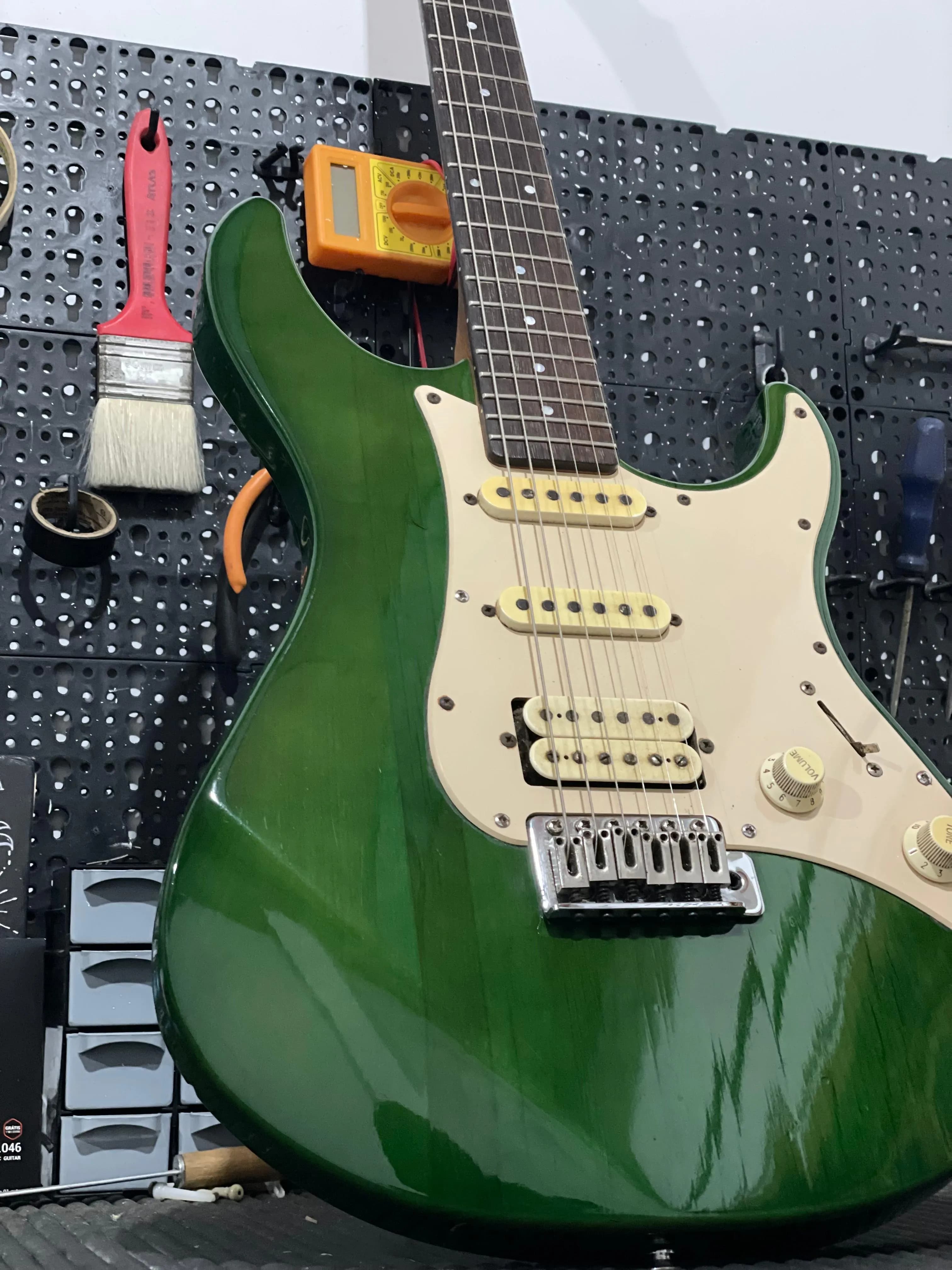Guitarra elétrica na oficina com ferramentas ao fundo