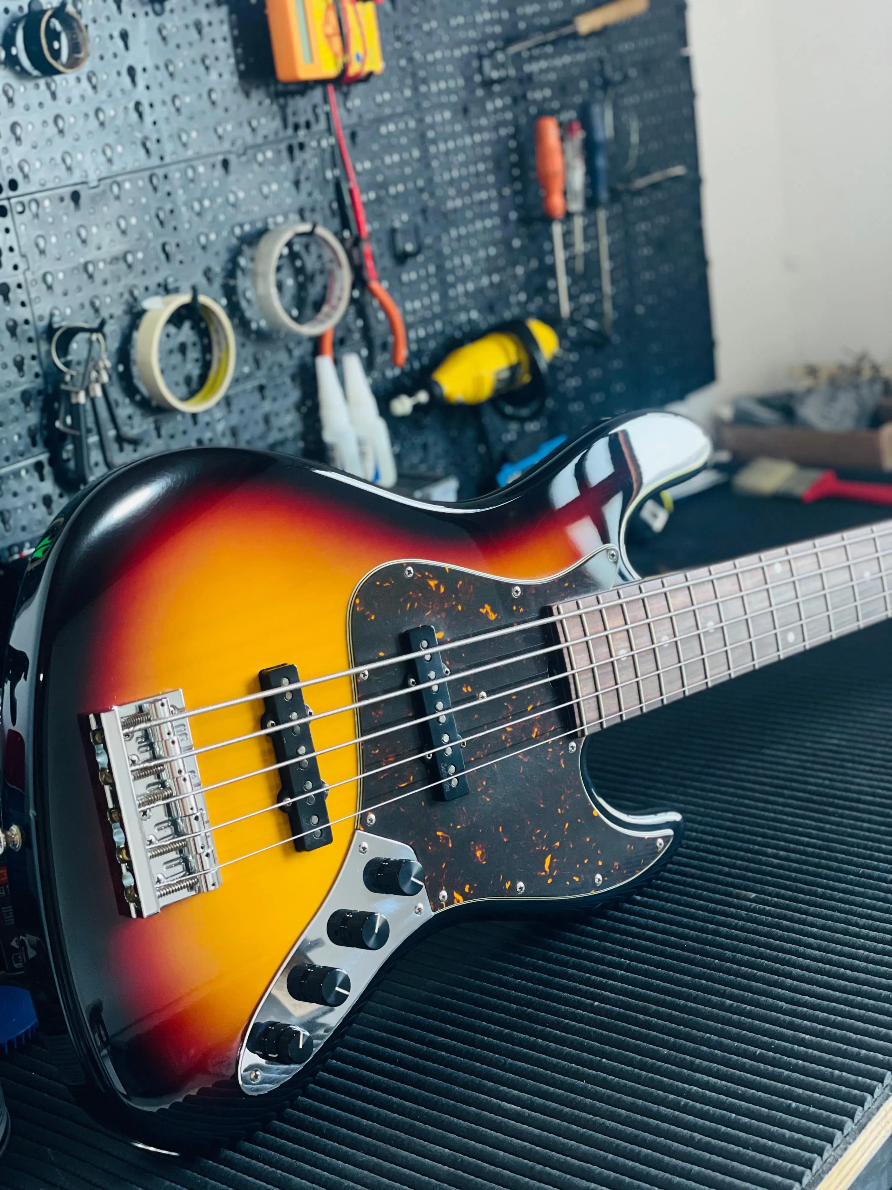 Baixo laranja estilo headless na oficina de luthieria